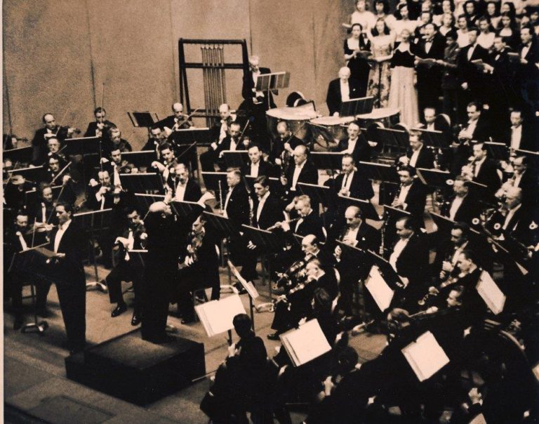 1945-46 season: Eugene Ormandy conducting a work for soloist, chorus, and orchestra. Photo by Adrian Siegel