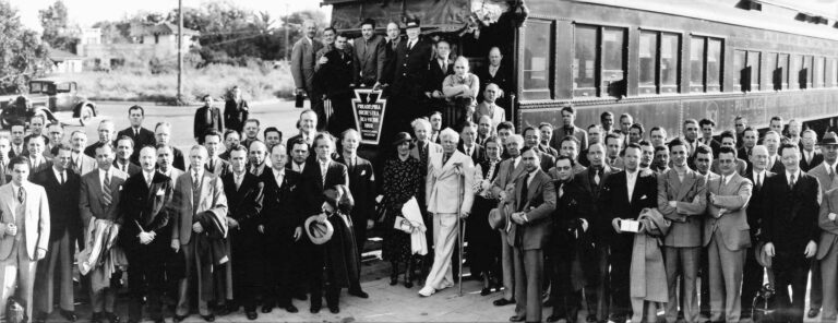Photograph of the Philadelphia Orchestra on its first coast-to-coast tour in 1936 with Leopold Stokowski. Tabuteau is standing on the train, stage-left of the train conductor. Stokowski is in the center standing next to the man in white attire with a crutch.